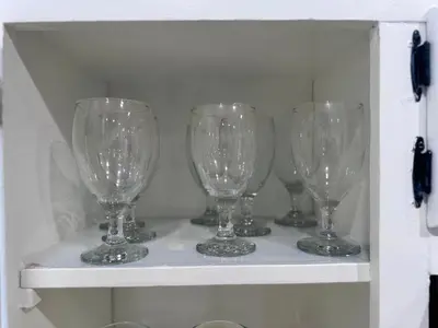 a row of wine glasses sitting on a shelf at Modern and Cozy Pine Hills Home from Early 1900s in Albany