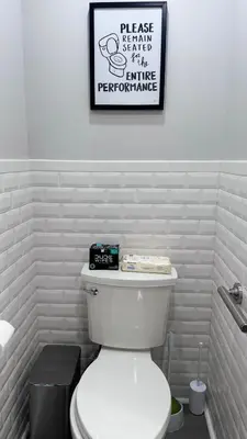 a bathroom with a toilet with a picture on the wall at Modern and Cozy Pine Hills Home from Early 1900s in Albany