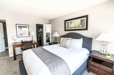 a bedroom with a white bed and a desk and a desk at Spacious Apt Downtown in Stamford