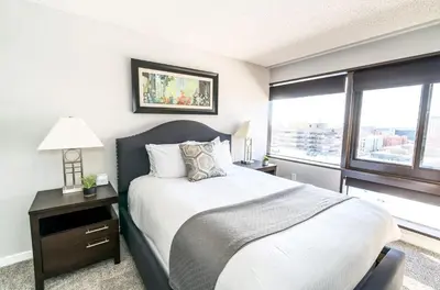 a bedroom with a bed and a large window at Spacious Apt Downtown in Stamford