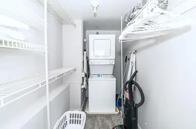 a laundry room with a washer and dryer and shelves at Spacious Apt Downtown in Stamford