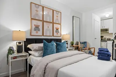 a bedroom with a large bed with blue pillows at Highly Recommended Studio Near Times Square in New York