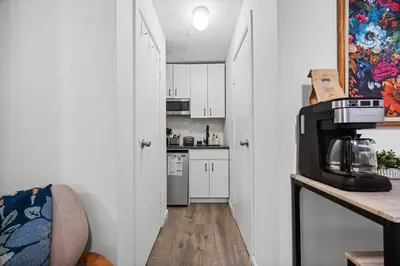 a kitchen with white cabinets and a counter with a microwave at Highly Recommended Studio Near Times Square in New York