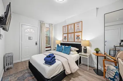 a bedroom with two beds and a tv in it at Highly Recommended Studio Near Times Square in New York