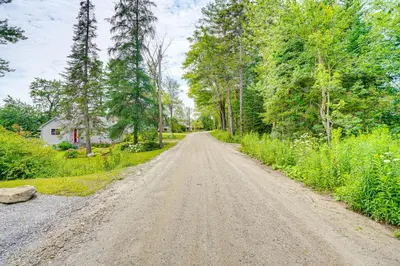 a dirt road with trees on both sides at Lakefront Hinsdale Home about 10 Mi to Pittsfield! in Hinsdale