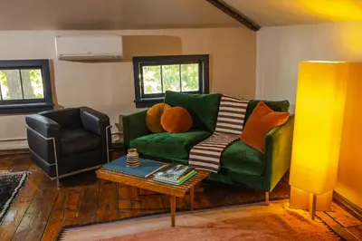 a living room with a green couch and a table at KIngston Carriage House in Kingston