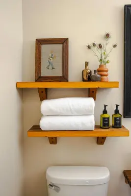 a bathroom with wooden shelves above a toilet at KIngston Carriage House in Kingston