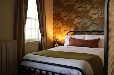 a bedroom with a bed with a floral wallpaper at KIngston Carriage House in Kingston
