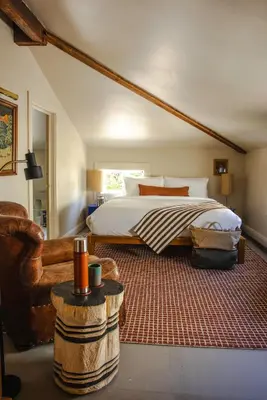 a bedroom with a bed and a couch and a chair at KIngston Carriage House in Kingston