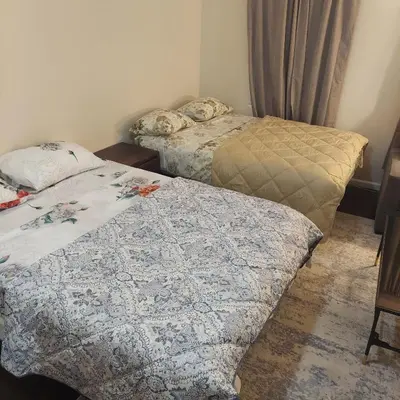 two beds sitting next to each other in a room at Double queen room 6 minutes walk to Penn station NYC EWR in Jersey City