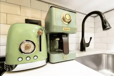 a green toaster sitting on top of a kitchen counter at The Green Room: 70s Groove Themed Studio in New York