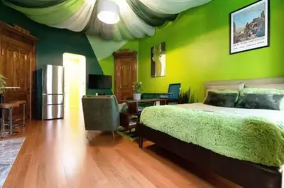 a bedroom with green walls and a bed and a desk at The Green Room: 70s Groove Themed Studio in New York