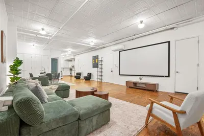 a living room with a couch and a white screen at Massive SoHo Loft 4 Bedrooms 2 Bath 8 beds in New York