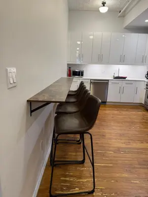 a counter in a kitchen with a black chair at Massive SoHo Loft 4 Bedrooms 2 Bath 8 beds in New York