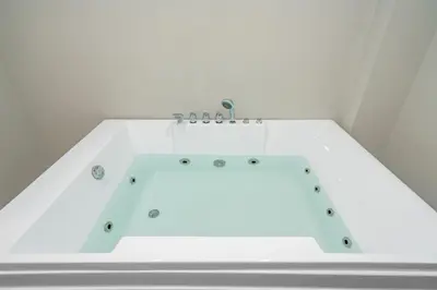 a bathtub in a white room with at Jetted Tub Stay in Passaic