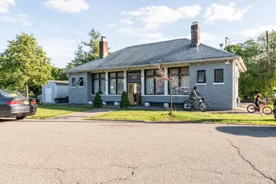 a house with two people riding bikes in front of it at Jetted Tub Stay in Passaic