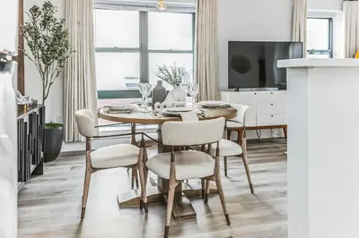 a dining room table with chairs and a television at Luxurious 1BR Downtown Stamford in Stamford