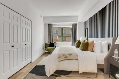 a white bedroom with a large bed and a window at Penthouse Perfection with Unmatched Skyline Views in Stamford