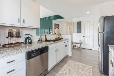 a kitchen with white cabinets and stainless steel appliances at Penthouse Perfection with Unmatched Skyline Views in Stamford