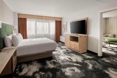 a hotel room with a bed and a flat screen tv at DoubleTree by Hilton Poughkeepsie in Poughkeepsie