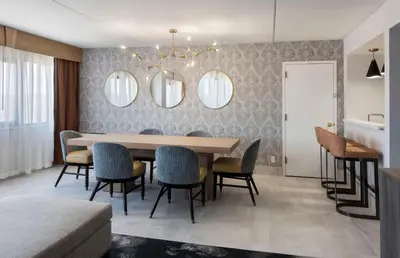 a dining room with a table and chairs and mirrors at DoubleTree by Hilton Poughkeepsie in Poughkeepsie