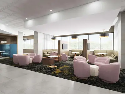 a lobby with pink chairs and tables and windows at DoubleTree by Hilton Poughkeepsie in Poughkeepsie