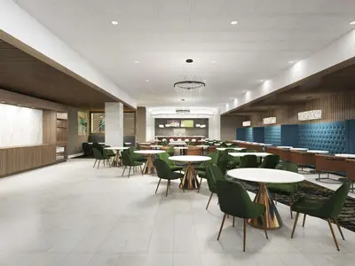 a dining room with tables and green chairs at DoubleTree by Hilton Poughkeepsie in Poughkeepsie