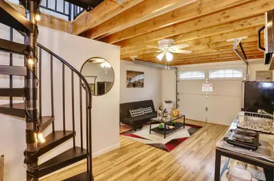 a living room with a staircase in a loft at NYC Loft Studio Near MetLife World Cup Stadium & Times Square in North Bergen