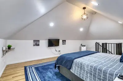 a bedroom with a bed and a tv on the wall at NYC Loft Studio Near MetLife World Cup Stadium & Times Square in North Bergen