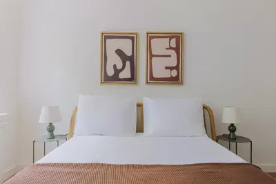 a bedroom with a white bed with two pictures on the wall at Blueground UES elev wd nr Museum Mile NYC-1530 in New York