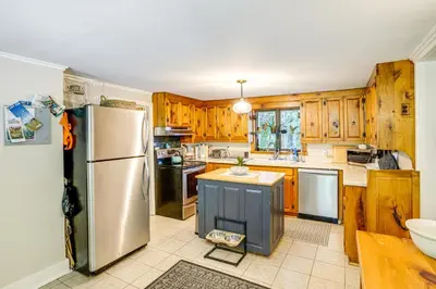 a kitchen with wooden cabinets and a stainless steel refrigerator at Historic Catskills Farmhouse Ski, Hike and Relax! in Catskill