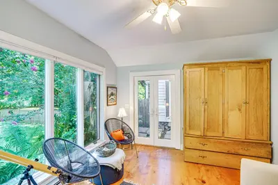 a living room with a ceiling fan and large windows at Historic Catskills Farmhouse Ski, Hike and Relax! in Catskill