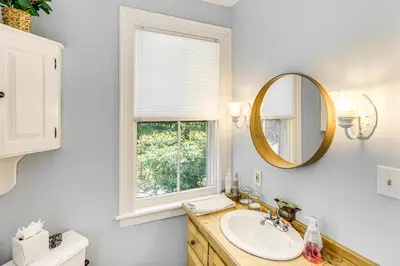 a bathroom with a sink and a mirror and a window at Historic Catskills Farmhouse Ski, Hike and Relax! in Catskill