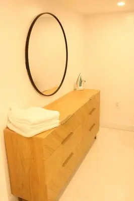 a bathroom with a mirror and a wooden dresser at Luxury king bed parking & washer in Schenectady