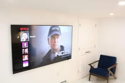 a flat screen tv hanging on a wall at Luxury king bed parking & washer in Schenectady