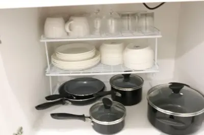 a kitchen counter with plates and pots and pans at Luxury king bed parking & washer in Schenectady