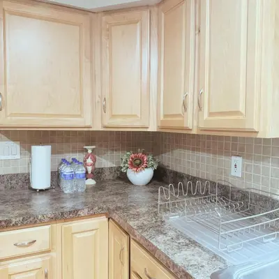 a kitchen counter with wooden cabinets and a sink at Quiet Cozy Stay Spacious Home Near Beach & Shops in Hamden