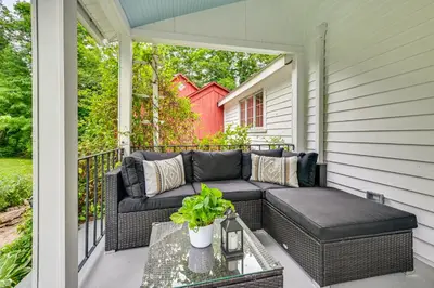 a screened in porch with a couch and a table at Historic Farmhouse Near Mountains and Colleges! in Westfield