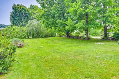 a large yard with green grass and trees at Historic Farmhouse Near Mountains and Colleges! in Westfield