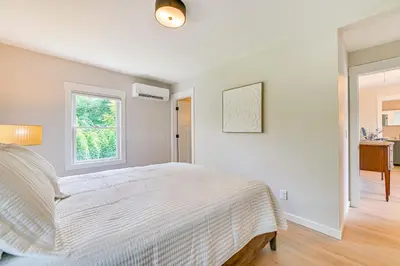 a white bedroom with a bed and a window at Saratoga Springs Home with Hot Tub Walk to Downtown in Saratoga Springs