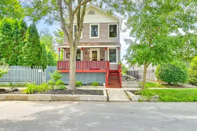 a house with a red porch and a fence at Saratoga Springs Home with Hot Tub Walk to Downtown in Saratoga Springs