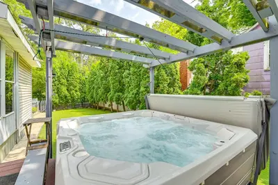 a hot tub on a patio with a pergola at Saratoga Springs Home with Hot Tub Walk to Downtown in Saratoga Springs