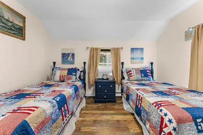 two beds sitting next to each other in a bedroom at Charming Fairfield Cottage By The Sea in Fairfield