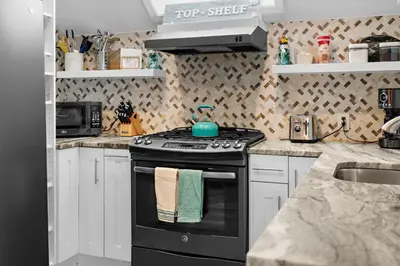 a kitchen with a black stove and a sink at Charming Fairfield Cottage By The Sea in Fairfield