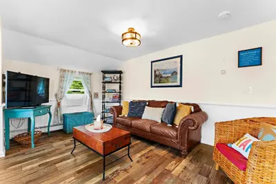a living room with a couch and a tv at Charming Fairfield Cottage By The Sea in Fairfield