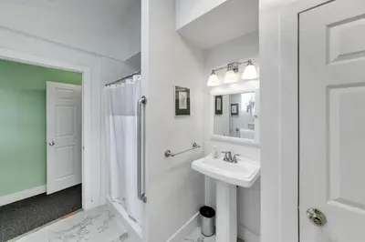 a white bathroom with a sink and a shower at Bear Pass - Mountain View home in Sunderland