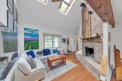 a living room with a white couch and a brick fireplace at Bear Pass - Mountain View home in Sunderland