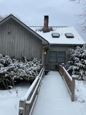 a house covered in snow with a wooden fence at Bear Pass - Mountain View home in Sunderland