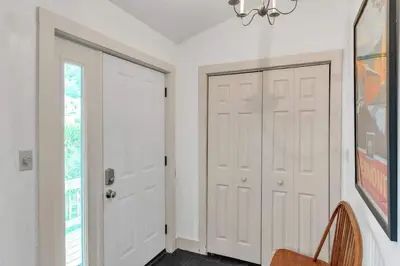 a hallway with two white doors and a chair at Bear Pass - Mountain View home in Sunderland