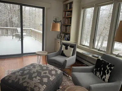 a living room with two chairs and a couch and windows at Bear Pass - Mountain View home in Sunderland